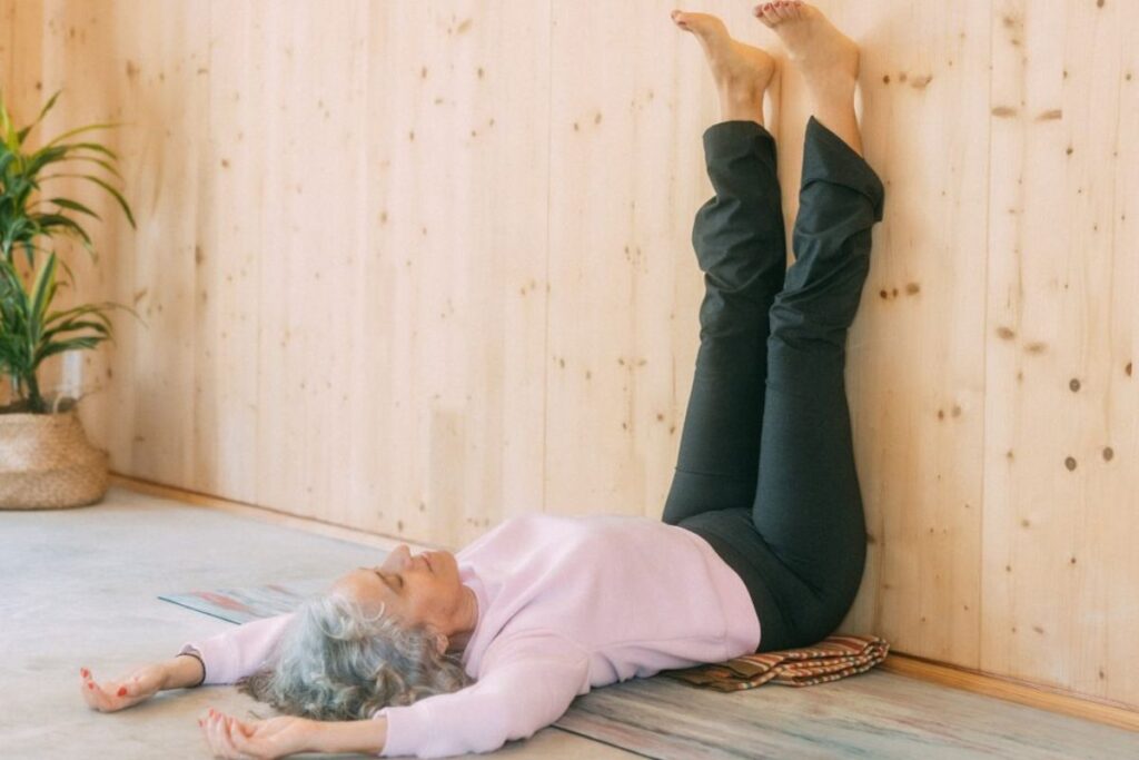 Postura de Oruga con las piernas apoyadas en la pared